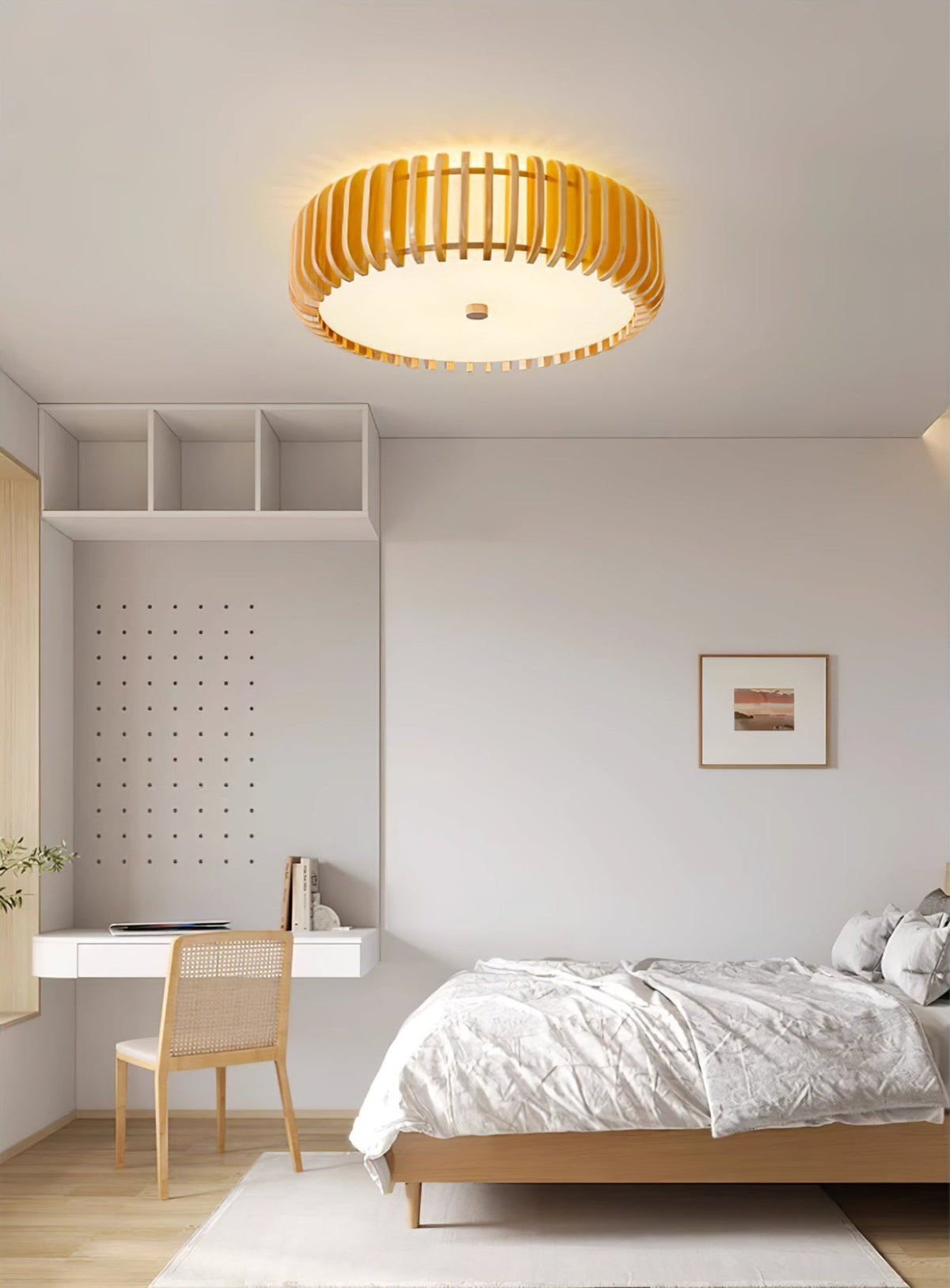 A rattan chair and desk sit below this Clérachic ceiling light, lit, in a pale bedroom.