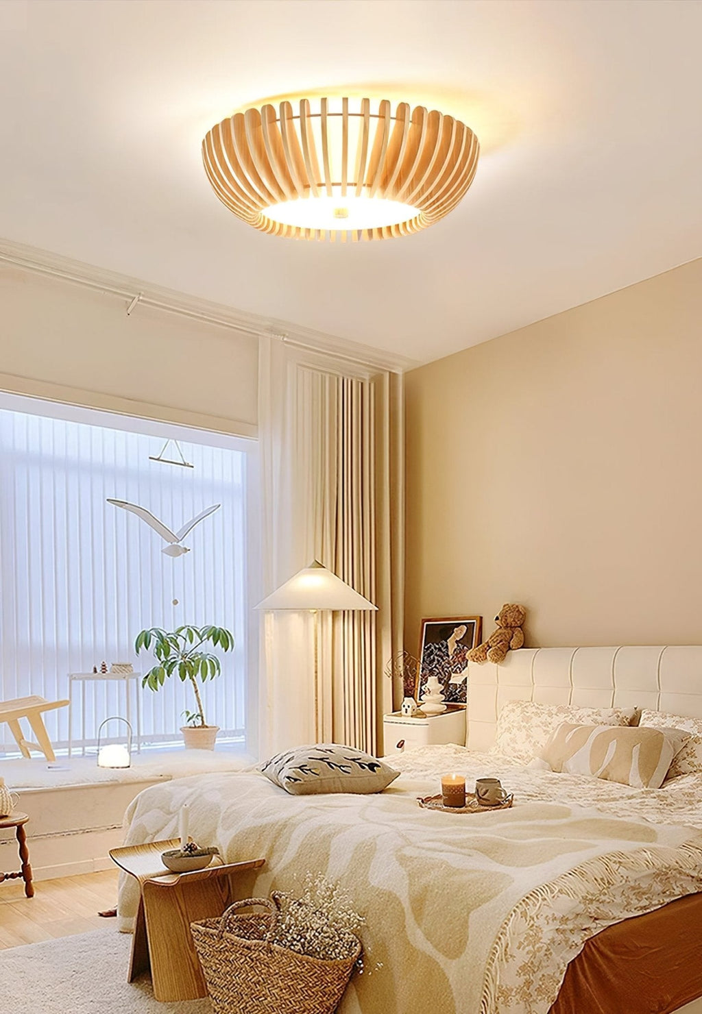 Sheer curtains and a window seat frame this Clérachic ceiling light, lit, in a small bedroom.