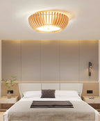 Wall sconces flank the bed below this Clérachic ceiling light, lit, on a dark accent wall.