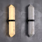 The sconce lit and unlit side by side, comparing the warm glow with the raw white stone.