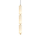 Warm light through the natural veining of the three stacked alabaster cylinders on the Zovarion pendant.