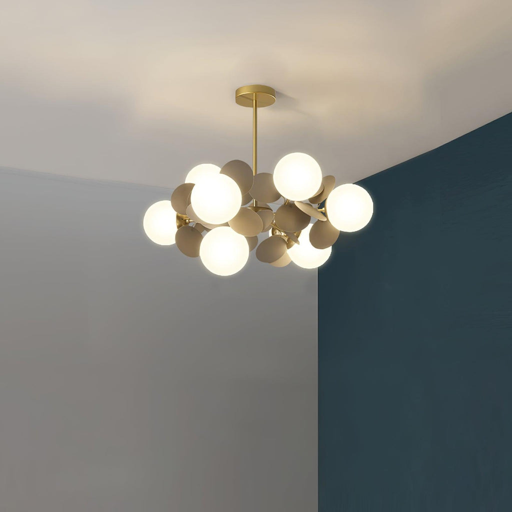 Tree chandelier shades glowing softly against a pale ceiling