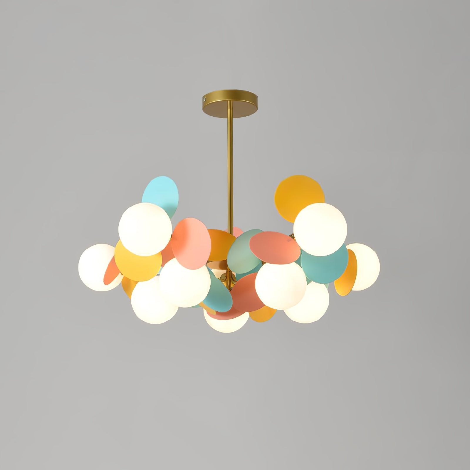 Tree chandelier lit against a neutral ceiling, warm light washing upward