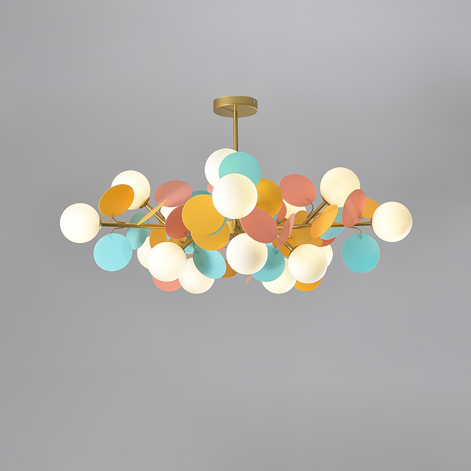 Branching gold chandelier arms holding open glass shades in close detail
