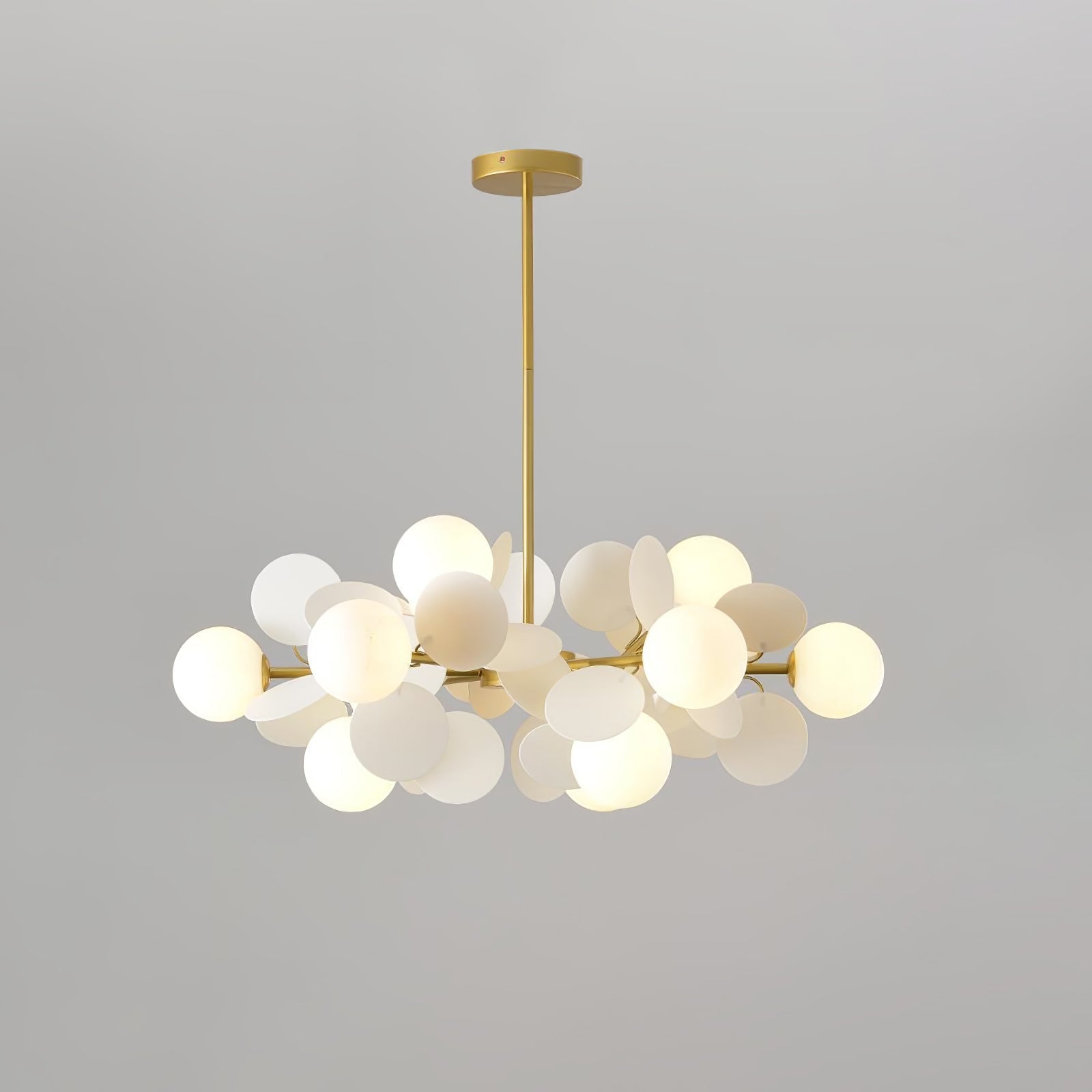 Detail of a single top-open glass shade seated in the gold branch arm