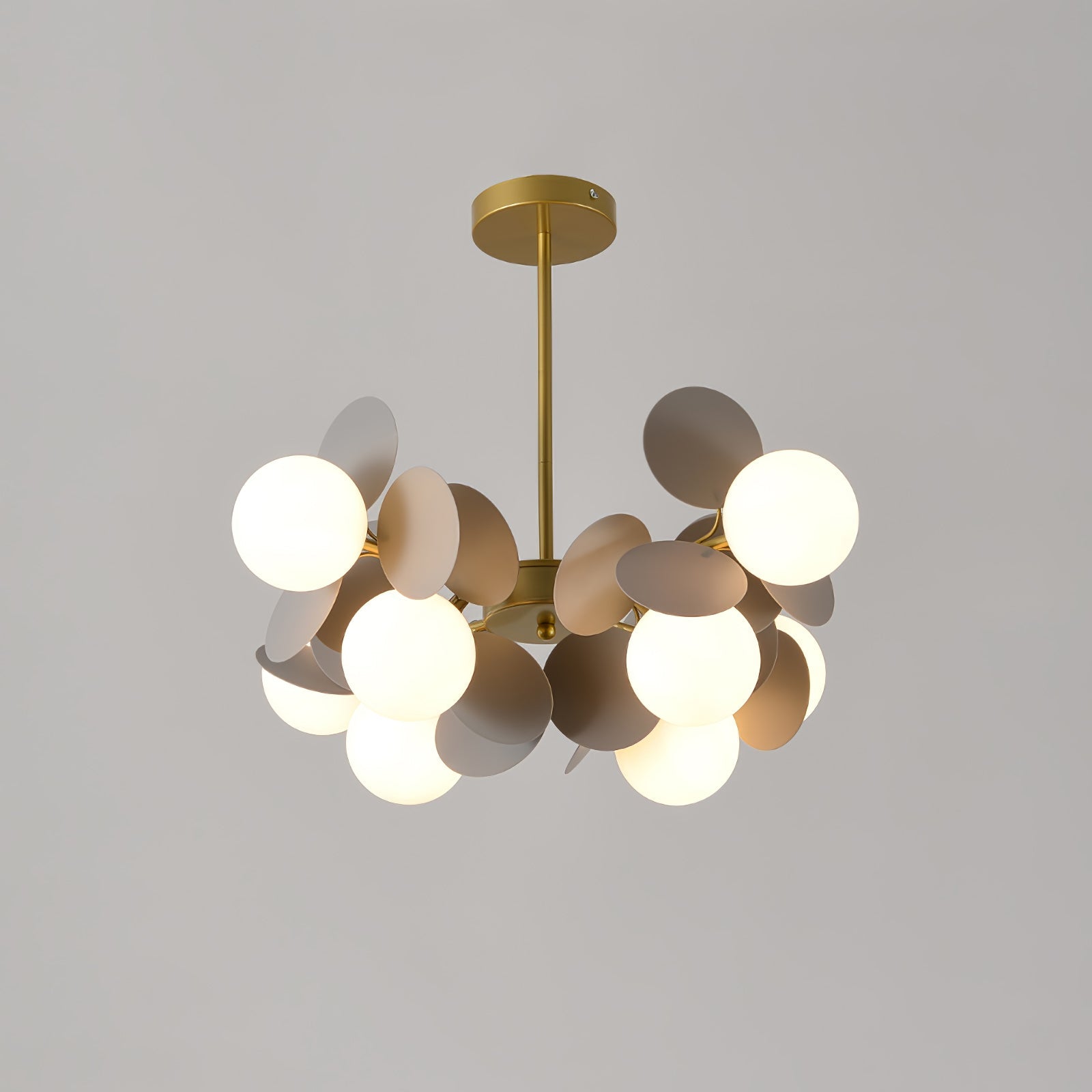 Gold tree chandelier casting warm upward light over a dining table