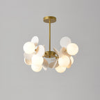 Tree chandelier with gold branching frame and top-open glass shades glowing in a styled living room