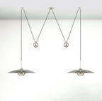 Round pendant light shown lit in a dim interior