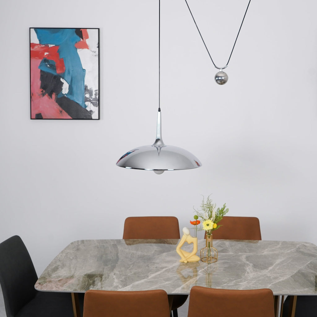 Round metal pendant light suspended in an interior space