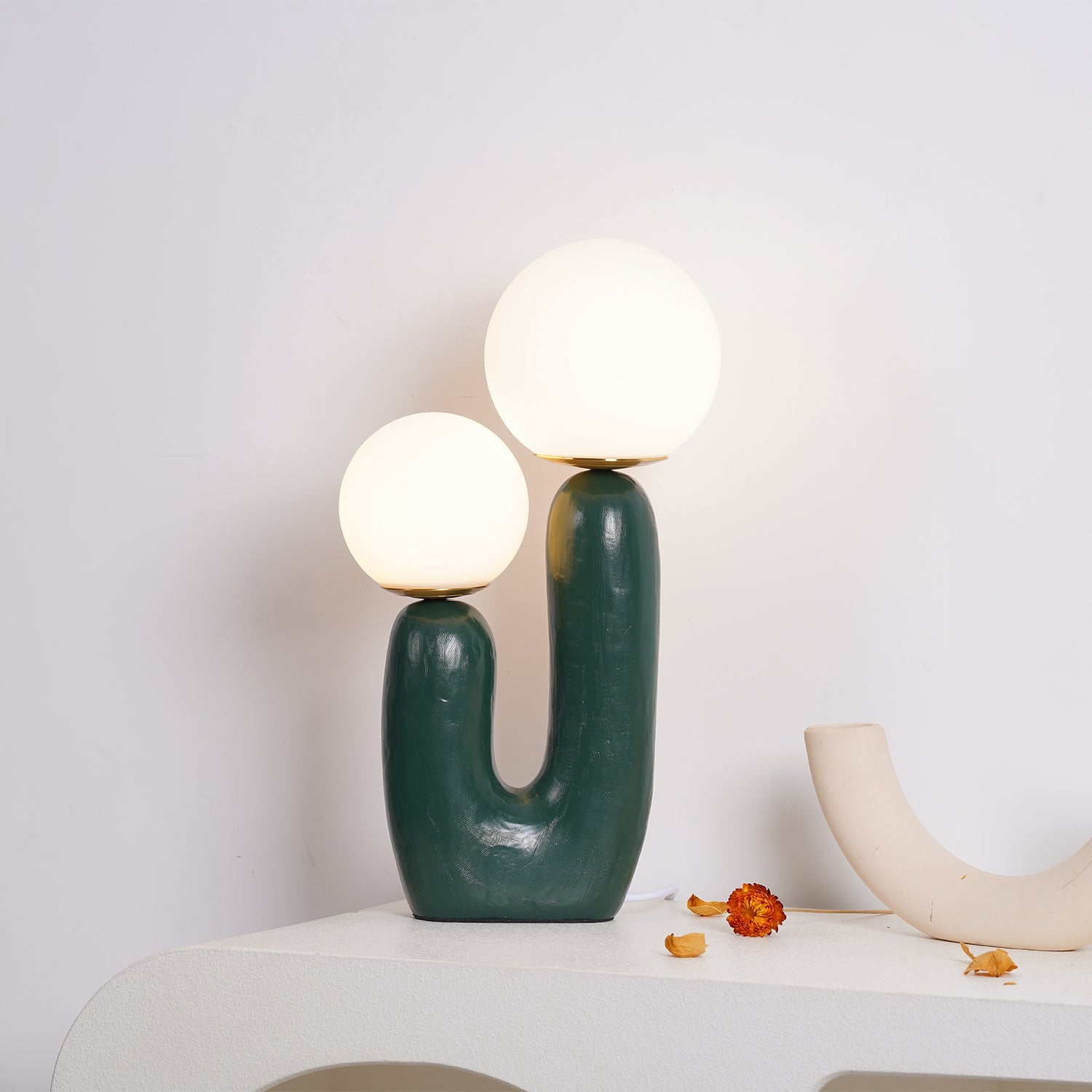 Sculptural table lamp lit in a cozy room corner