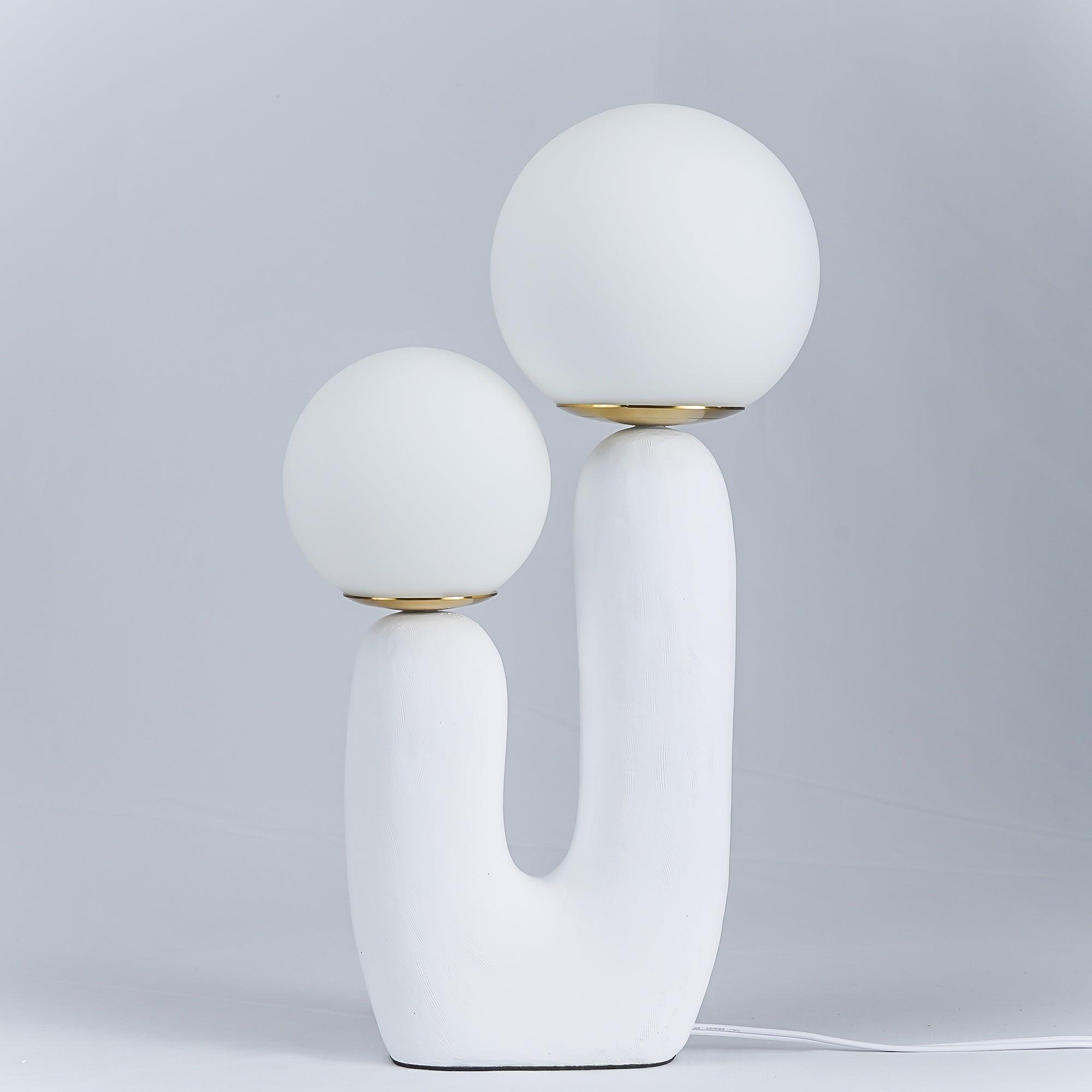 White glass globe table lamp lit on a side table