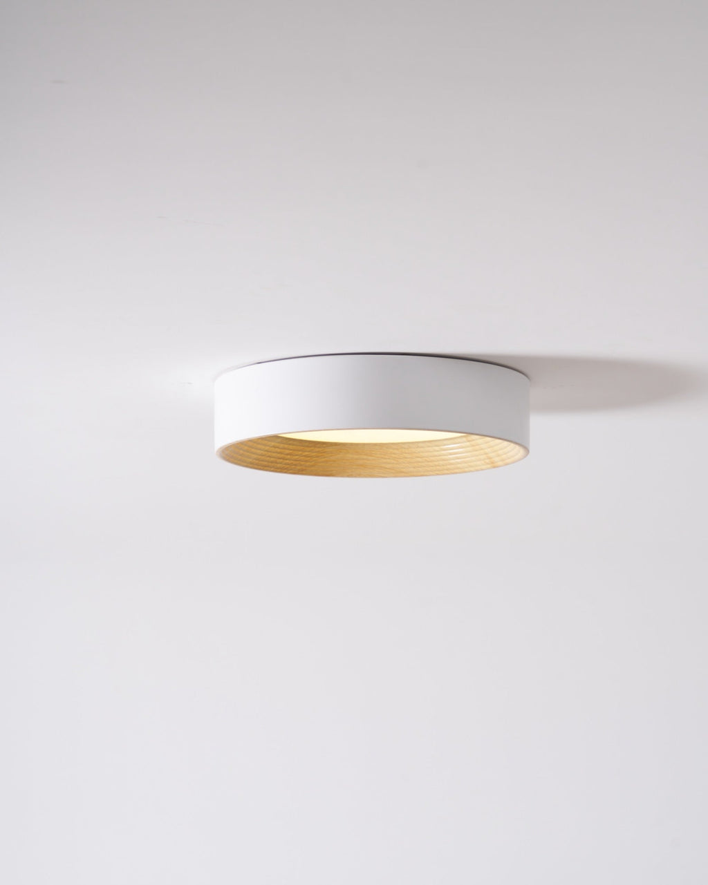 Round ceiling light lit in a calm modern room