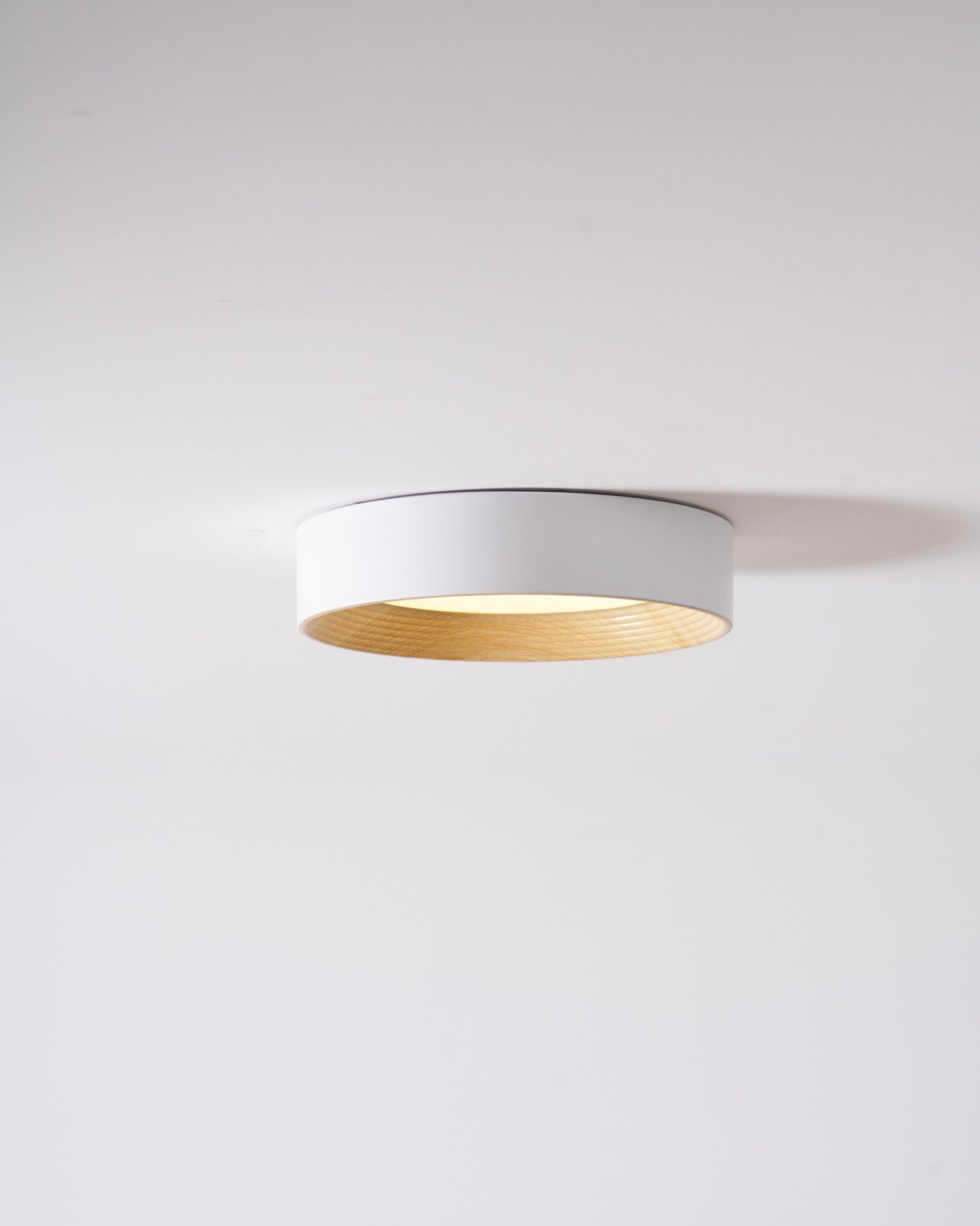 Round ceiling light lit in a calm modern room