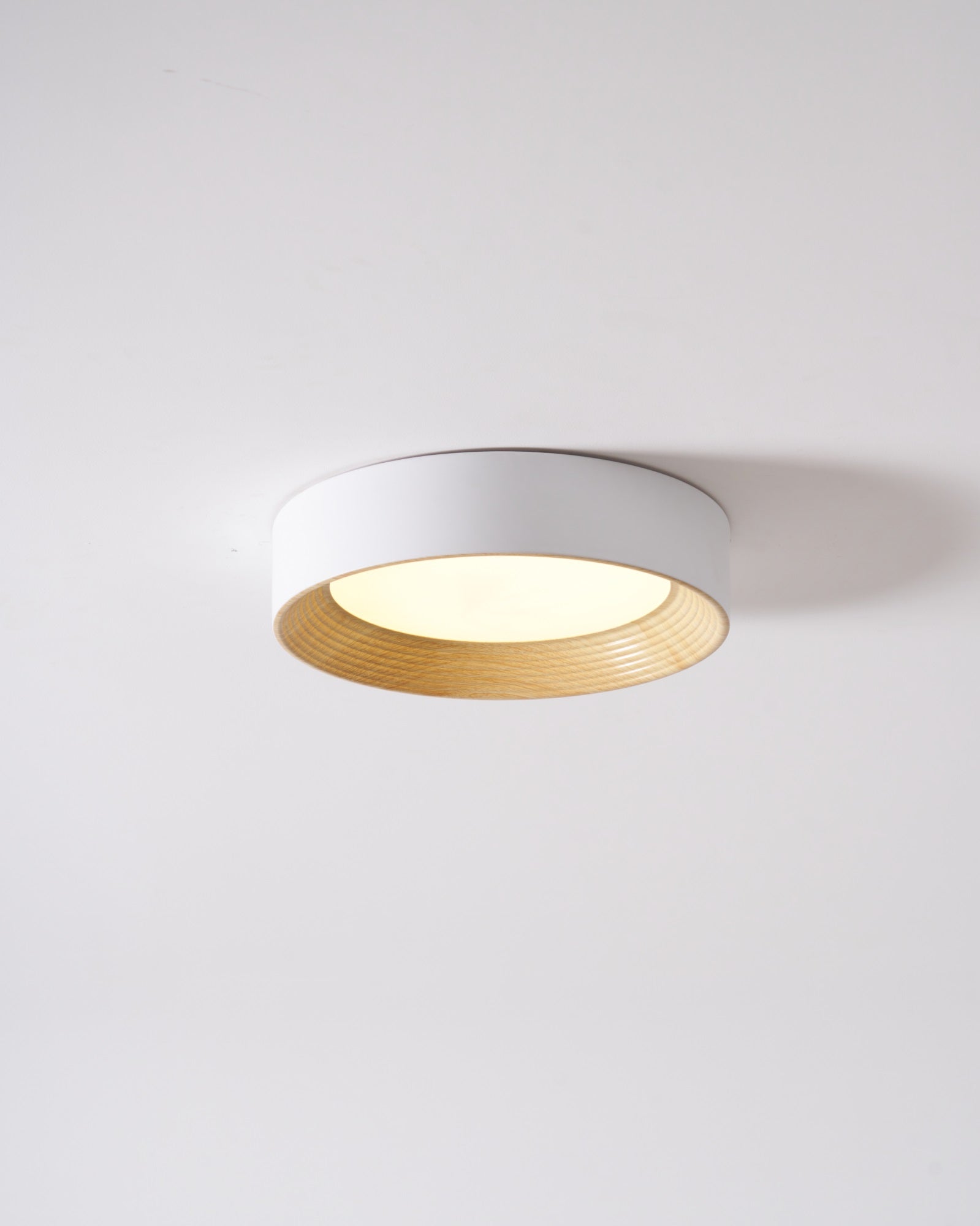 Wood-tone flush mount light shown from an angle