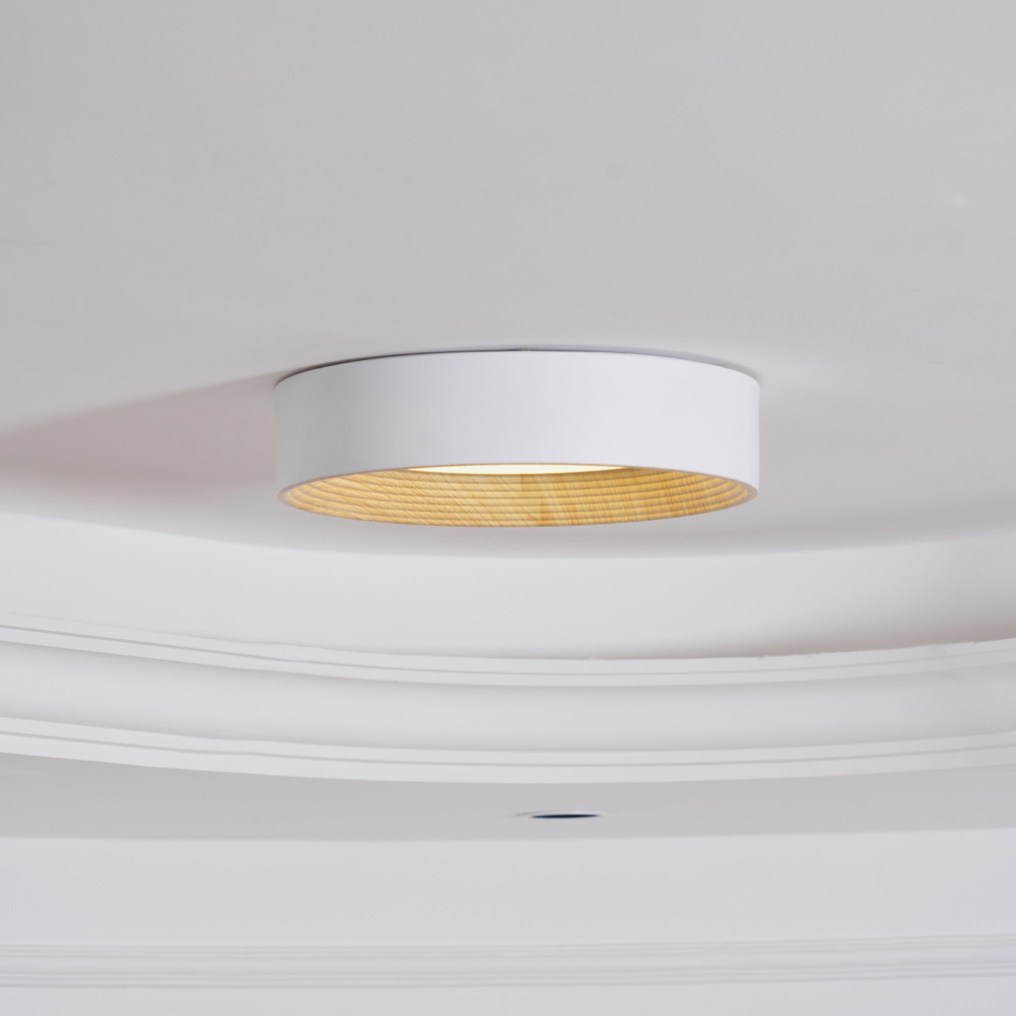 Round wood-tone ceiling light glowing in the evening