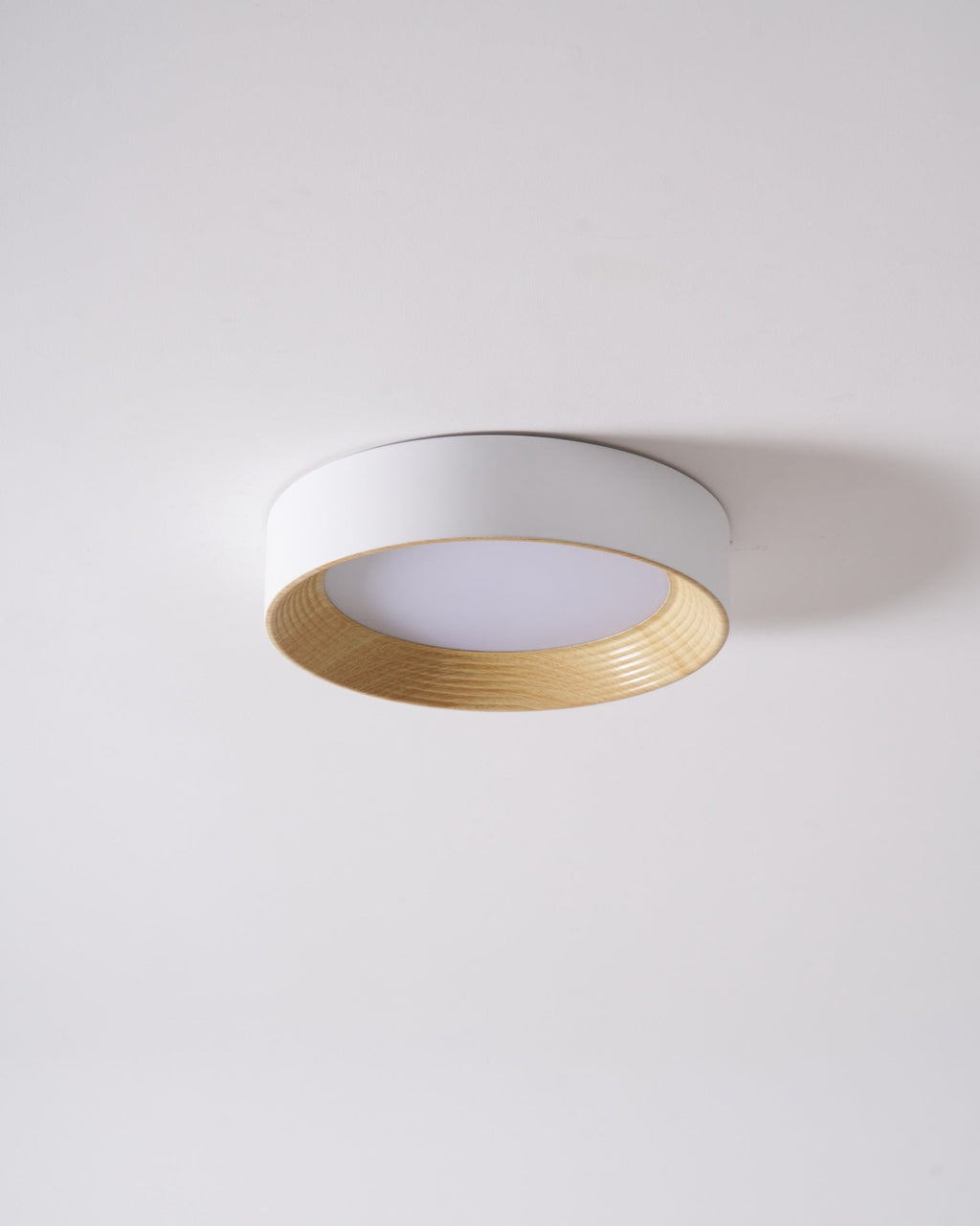 Round flush mount light with slim wood-tone profile