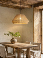 Hanging beneath rustic wood ceiling beams, this Clérachic pendant sits above a reclaimed wood dining table.