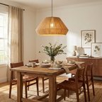 This Clérachic pendant in beige linen hangs above a wood dining table laid with bowls, framed botanical prints on the wall behind.