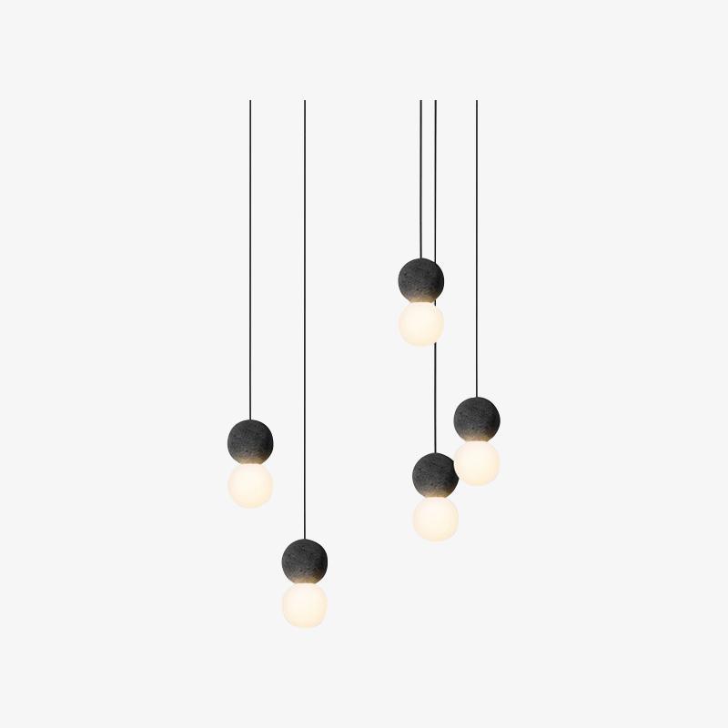 Several Clérachic pendants of varying drop lengths hang together against a plain off-white backdrop.