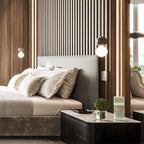 A single Clérachic pendant hangs beside an upholstered headboard in a bedroom with wood-slat panelling.