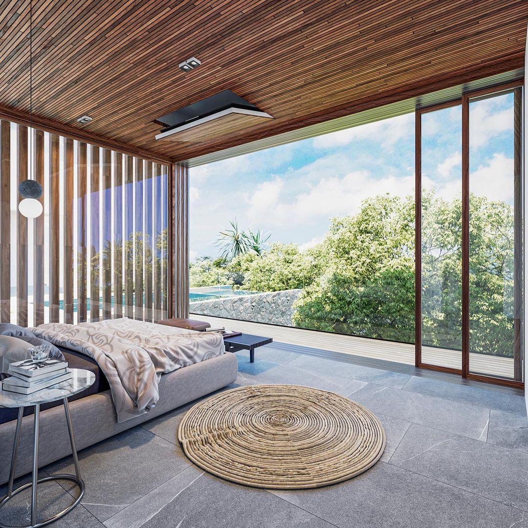 A single Clérachic pendant hangs near floor-to-ceiling glass doors, overlooking a garden and pool from a minimalist living room.
