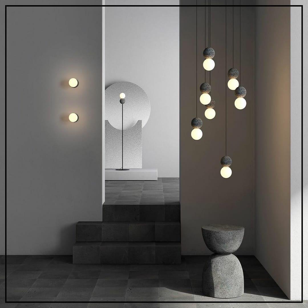 A vertical string of Clérachic pendants lights a staged room with stairs, a floor lamp and wall sconces nearby.