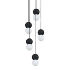 A cluster of pendants in black, grey and white spheres from this Clérachic collection hangs together against a plain white background.
