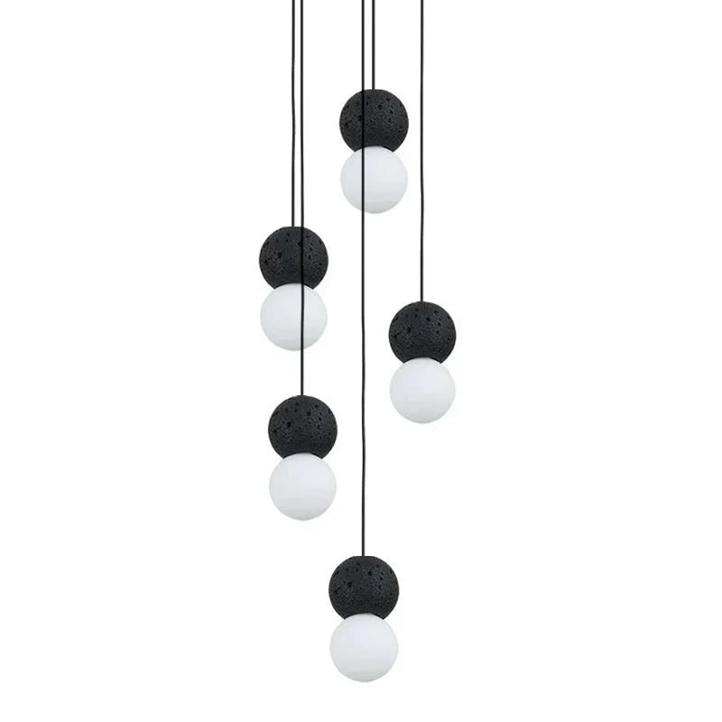 A cluster of pendants in black, grey and white spheres from this Clérachic collection hangs together against a plain white background.
