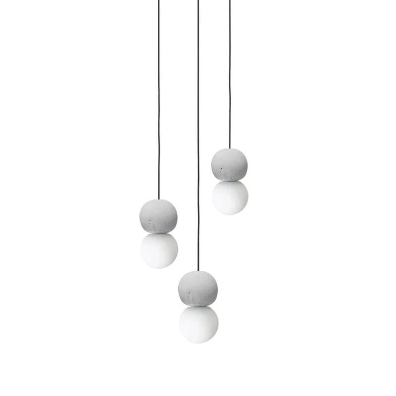 A cluster of pale sphere pendants from this Clérachic collection hangs at staggered heights against a plain white background.
