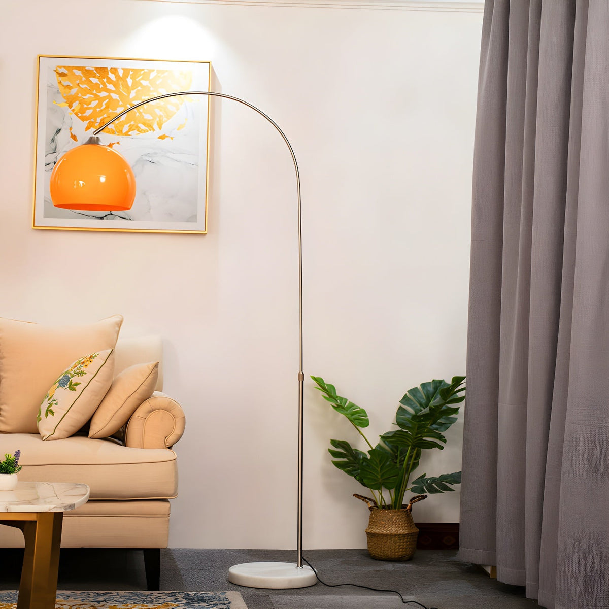 The same room shows a Clérachic arc floor lamp fitted with an orange dome shade instead of white, unlit by the armchair.