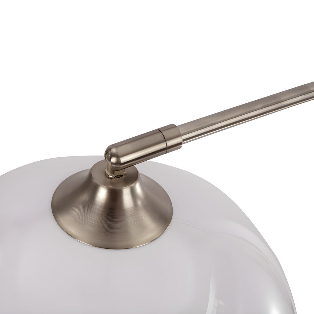 Close-up of the brushed nickel arm meeting a matte white dome shade on a Clérachic arc floor lamp.