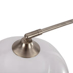 Close-up of the brushed nickel arm meeting a matte white dome shade on a Clérachic arc floor lamp.