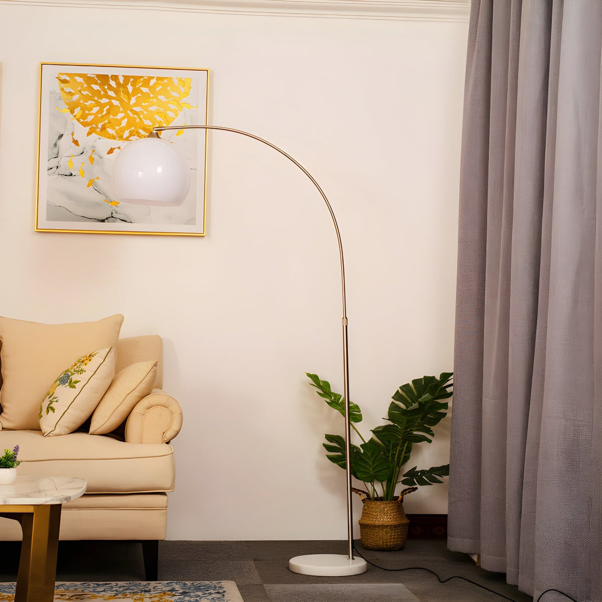A Clérachic arc floor lamp with a white dome shade curves over a cream armchair near a window with mauve curtains.