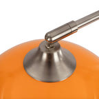 Close-up of the brushed nickel joint where a Clérachic arc floor lamp's arm meets its glossy orange dome shade.