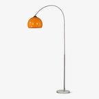 A Clérachic arc floor lamp with a nickel curve and orange dome shade stands on its round marble base against plain grey.