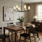 In a dining room with black spindle-back chairs, this Clérachic chandelier lights a long wood table in matte black.