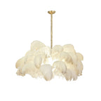 Ostrich feather chandelier in neutral plumes above a dining table