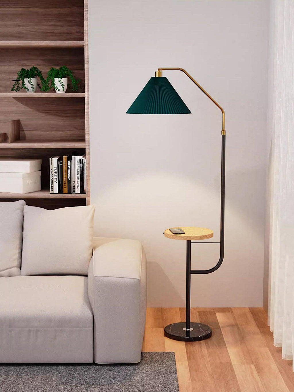 Clérachic floor lamp against the bookshelf backdrop, green shade lit in a closer crop above a wood tray holding a phone.