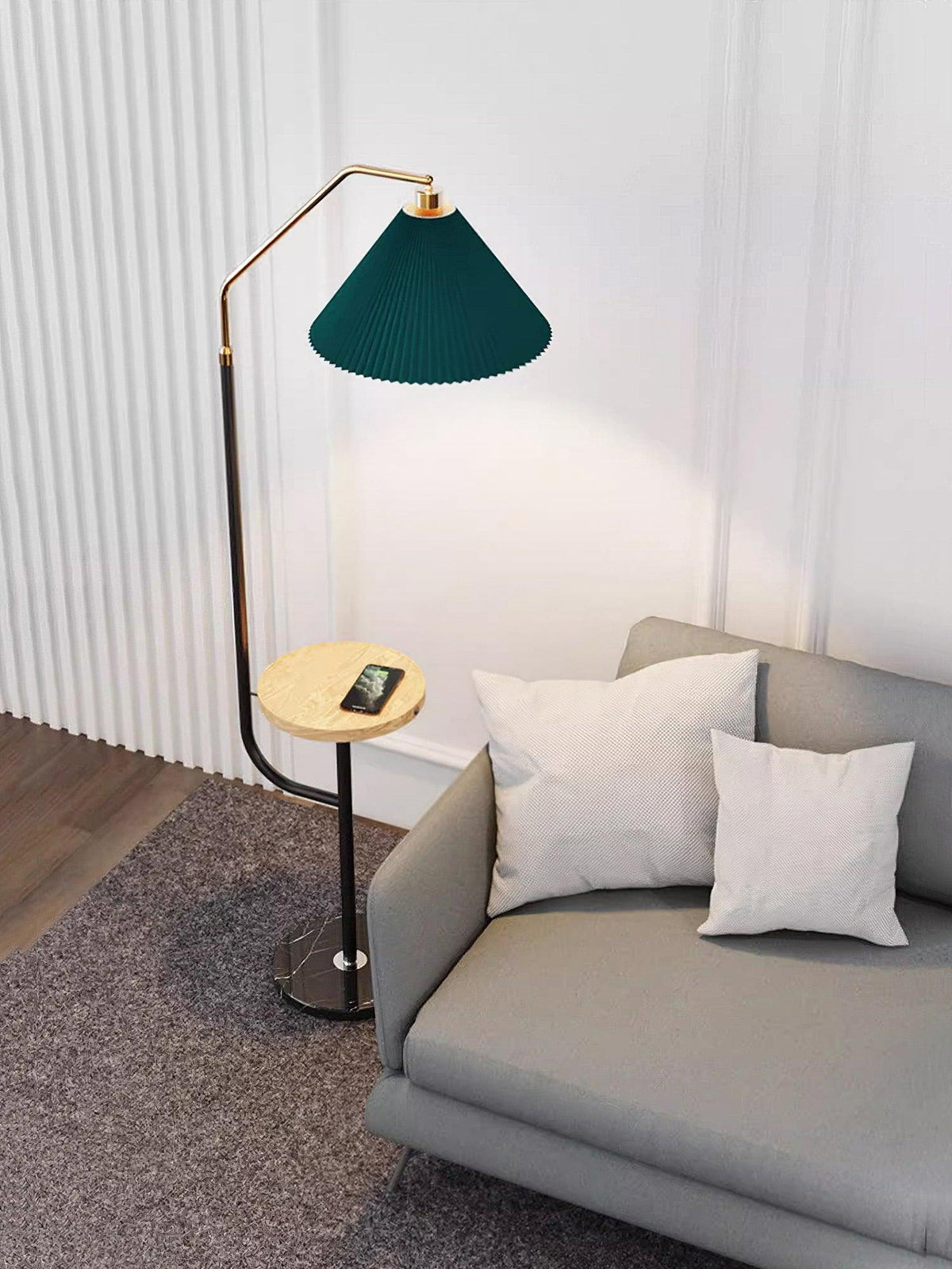 Clérachic floor lamp in the same panelled room, green shade lit above a wood tray holding a phone, shown from a slightly wider angle.