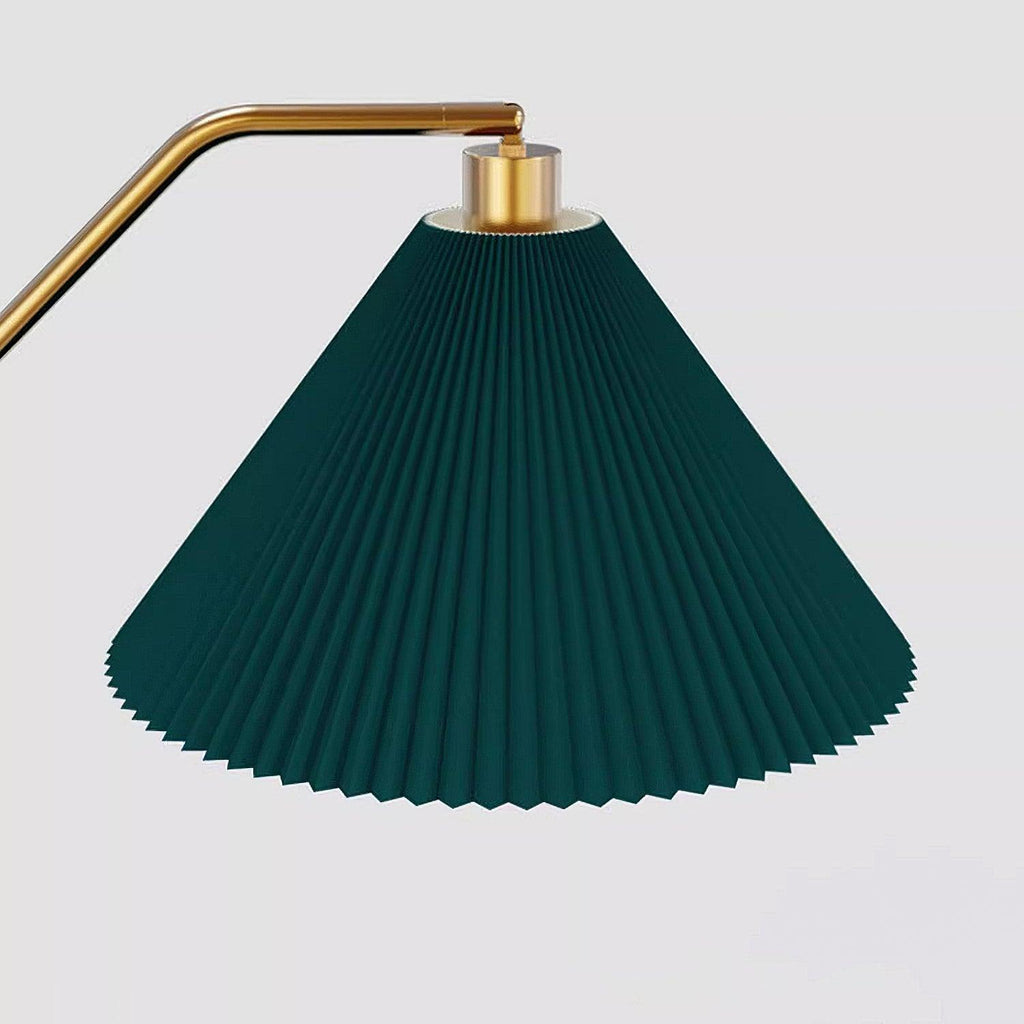Close-up of the Clérachic floor lamp's pleated green fabric shade and brass gallery, showing the ribbed pleating in detail against a plain background.