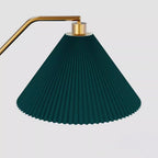 Close-up of the Clérachic floor lamp's pleated green fabric shade and brass gallery, showing the ribbed pleating in detail against a plain background.