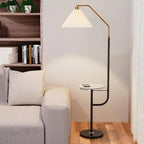 Clérachic floor lamp against the same bookshelf backdrop, cream shade lit above a marble-topped tray holding a phone.