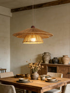 Ceramic dishes and dried flowers dress a rustic wood table beneath this Clérachic pendant's warm glow.