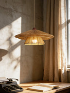 Sunlight streams past the curtain onto a wood desk with a typewriter, lit by this Clérachic pendant above.