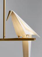 Bird chandelier detail of gold rod and softly lit acrylic bird