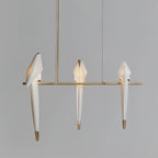 Bird chandelier glowing gently above a seating area