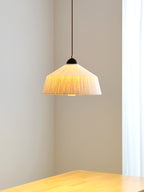 In a plain corner above a wood table's edge, this Clérachic pendant's beige rice paper shade glows warm.