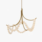 Gold Parel chandelier lit on a white background, showing the crossed arms and four bead swags