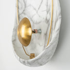 Close side view of the brass orb, its stem and the bolt that holds it to the back of the shell.