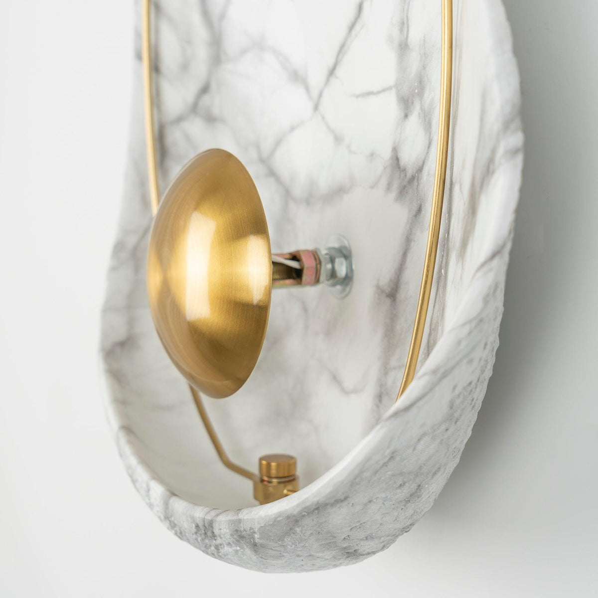 Close side view of the brass orb, its stem and the bolt that holds it to the back of the shell.